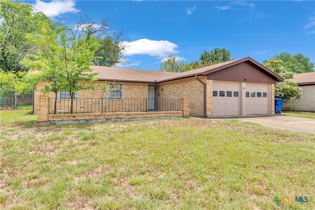 ranch-style home featuring a garage and a front lawn