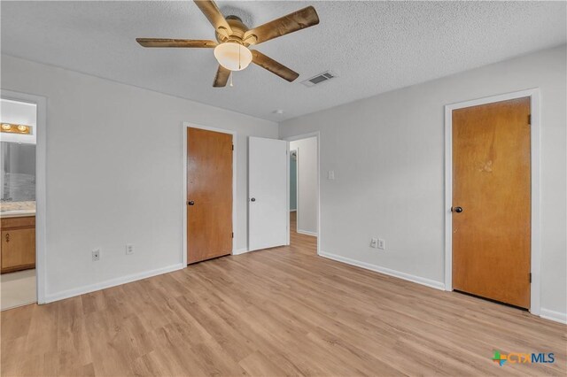 1123 Rhonda Lee St, Copperas Cove, TX 76522 - unfurnished bedroom with light wood-type flooring, baseboards, a textured ceiling, and ensuite bath