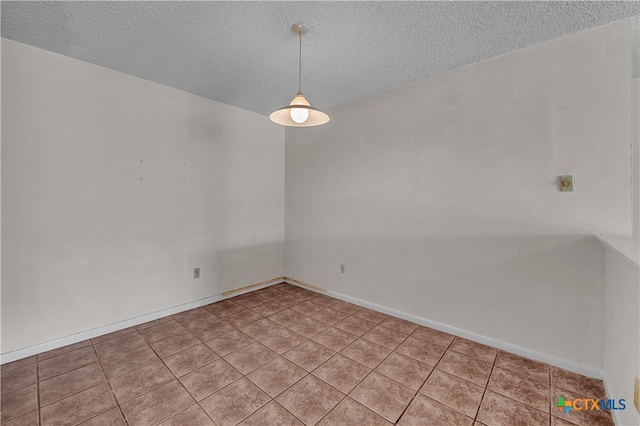 tiled spare room with a textured ceiling