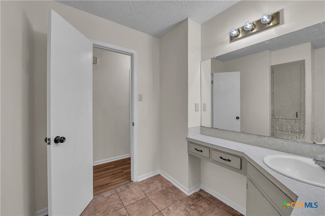 bathroom featuring vanity, tile patterned floors, and a textured ceiling