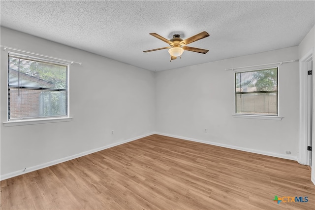 unfurnished room with light wood-type flooring, a wealth of natural light, and ceiling fan