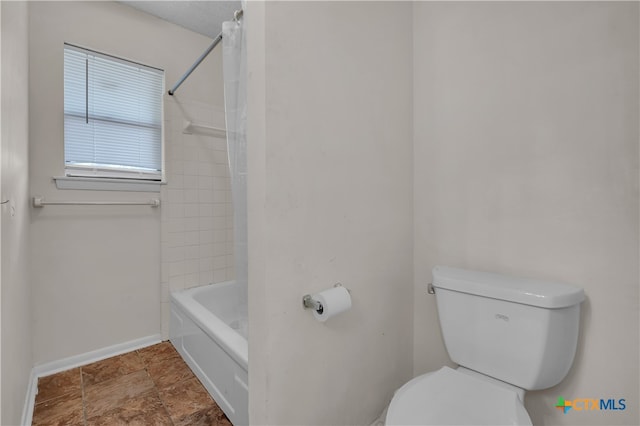 bathroom featuring tiled shower / bath and toilet