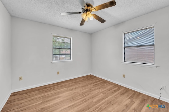 spare room with light hardwood / wood-style floors, ceiling fan, and a textured ceiling