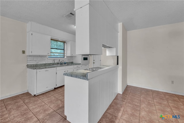 kitchen featuring white dishwasher, white cabinets, a textured ceiling, sink, and light tile patterned floors