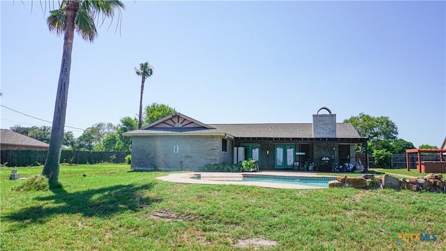 rear view of property with a yard