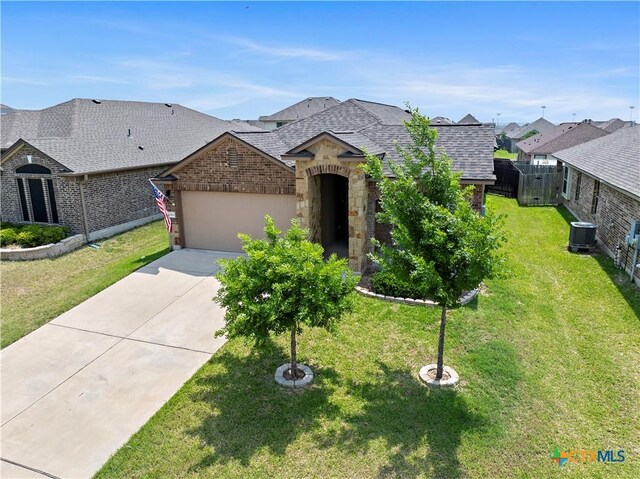 1313 Juneberry Park Dr, Temple, TX 76502 - french country home with cooling unit, roof with shingles, a garage, driveway, and stone siding