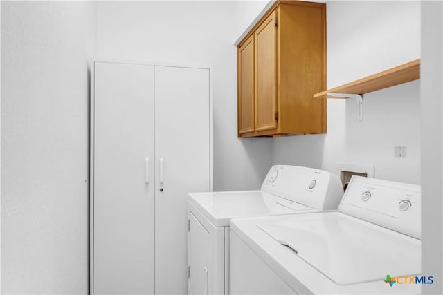 washroom featuring washing machine and clothes dryer and cabinets