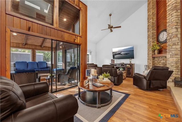 living room with light wood-type flooring, wood ceiling, ceiling fan, beam ceiling, and high vaulted ceiling