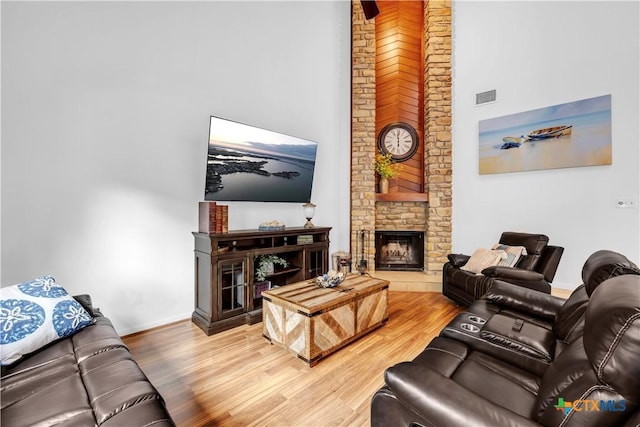 living room with hardwood / wood-style floors and a large fireplace