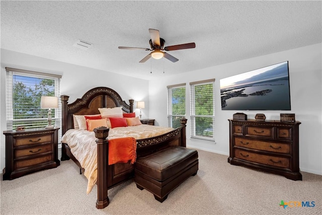 carpeted bedroom with a textured ceiling and ceiling fan