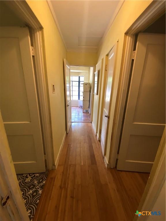 948 Sycamore St, San Marcos, TX 78666 - hallway featuring crown molding, wood finished floors, and baseboards