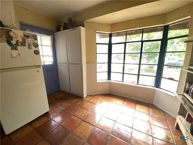 948 Sycamore St, San Marcos, TX 78666 - kitchen with freestanding refrigerator, healthy amount of natural light, and tile patterned floors