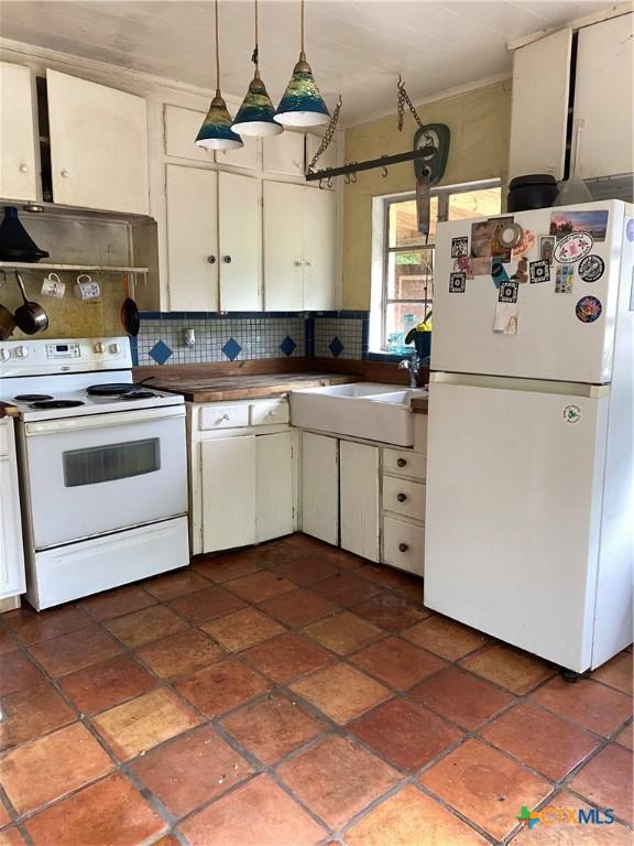 948 Sycamore St, San Marcos, TX 78666 - kitchen with white appliances, backsplash, custom exhaust hood, and white cabinets