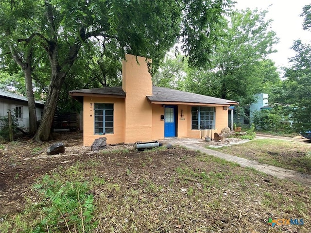 948 Sycamore St, San Marcos, TX 78666 - view of front of property with a chimney, stucco siding, and view of scattered trees