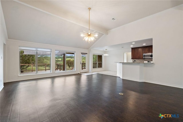 215 Maverick Cir, Horseshoe Bay, TX 78657 - unfurnished living room with a chandelier, plenty of natural light, dark wood-style floors, beamed ceiling, and high vaulted ceiling