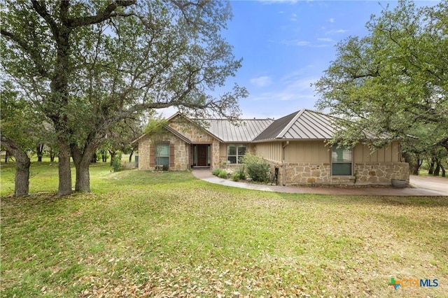 215 Maverick Cir, Horseshoe Bay, TX 78657 - view of front of house with stone siding, a front lawn, a metal roof, and board and batten siding