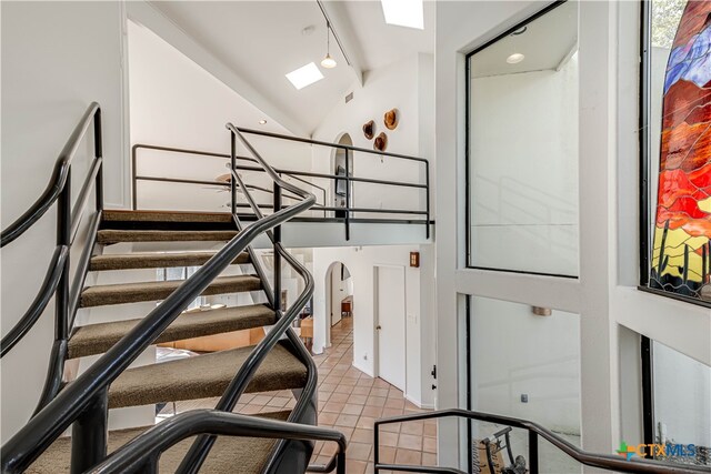 stairs with lofted ceiling and tile patterned flooring