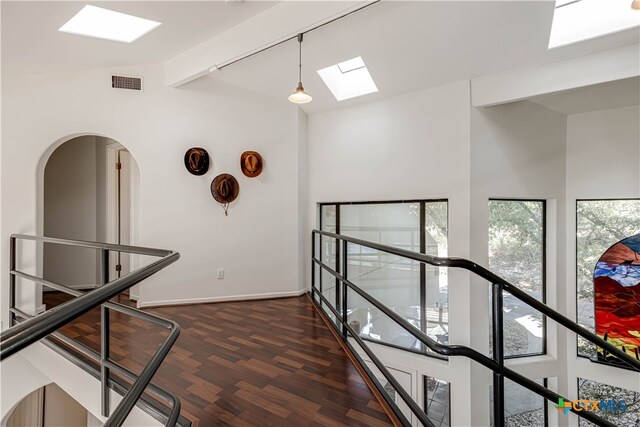 hall featuring lofted ceiling with beams, baseboards, visible vents, and dark wood-type flooring