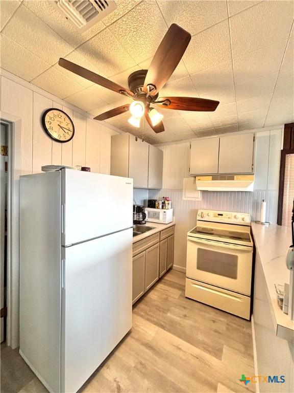 kitchen featuring white appliances, ceiling fan, and light wood-type flooring