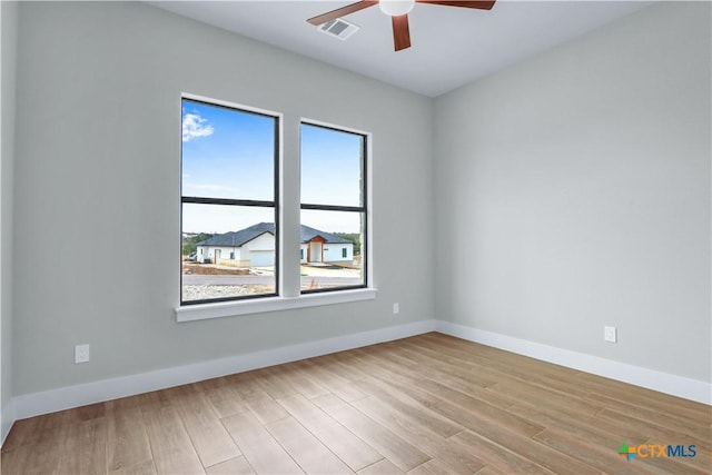 empty room with ceiling fan and light hardwood / wood-style floors