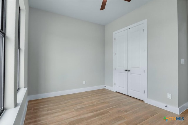 unfurnished bedroom featuring a closet, ceiling fan, and light hardwood / wood-style flooring