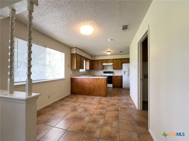 1804 Kingman Rd, Killeen, TX 76549 - kitchen with white appliances, under cabinet range hood, a peninsula, light countertops, and a textured ceiling