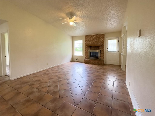 1804 Kingman Rd, Killeen, TX 76549 - unfurnished living room with a textured ceiling, ceiling fan, tile patterned floors, and a fireplace