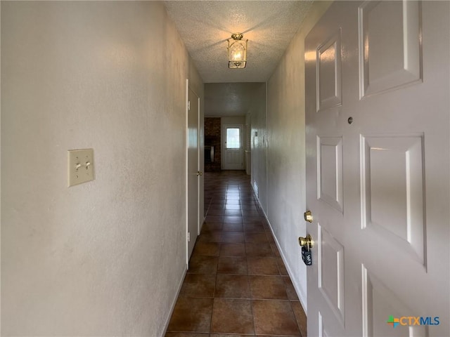 1804 Kingman Rd, Killeen, TX 76549 - corridor with a textured ceiling, dark tile patterned flooring, and a textured wall
