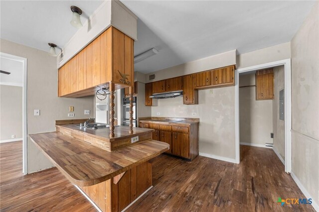 3105 Julie Ln, Killeen, TX 76549 - kitchen featuring white oven, dark wood finished floors, and brown cabinetry