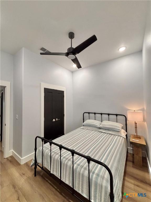 bedroom with hardwood / wood-style flooring and ceiling fan