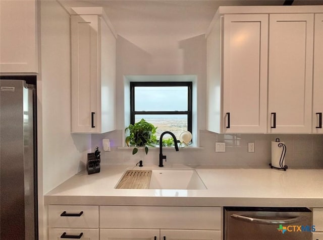 kitchen with stainless steel appliances, sink, and white cabinets