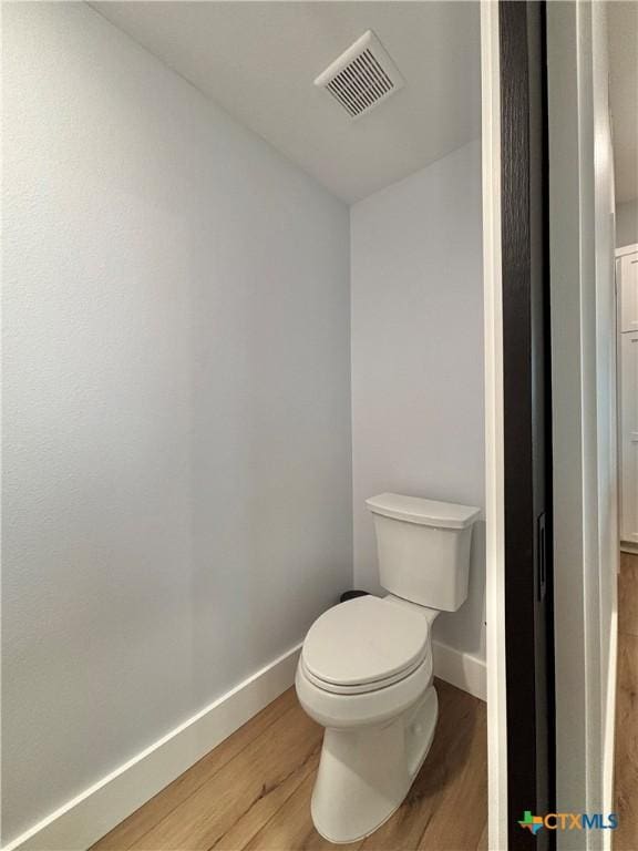 bathroom featuring wood-type flooring and toilet