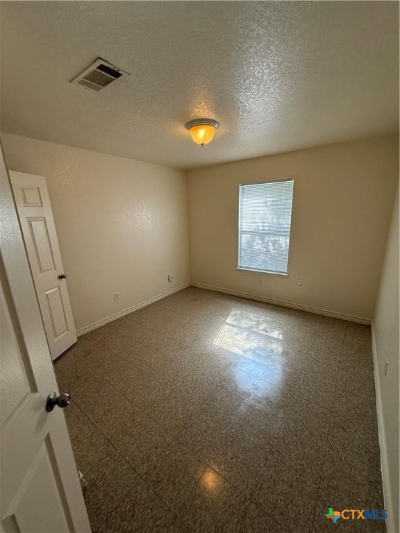 705 N 2nd St, Temple, TX 76501 - empty room featuring baseboards and a textured ceiling