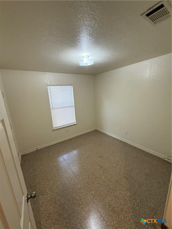 705 N 2nd St, Temple, TX 76501 - spare room with a textured ceiling and baseboards