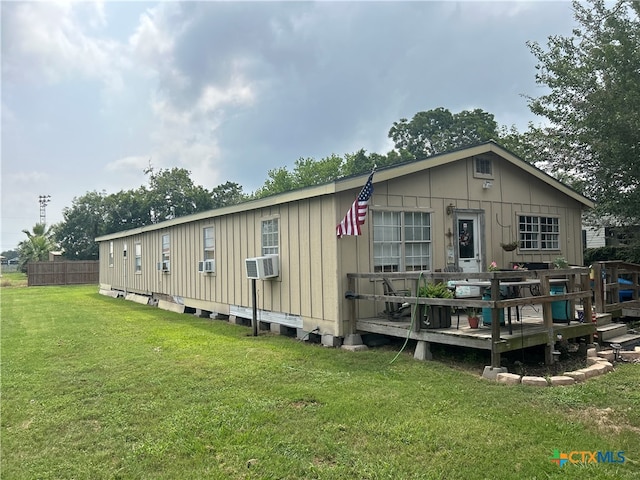 back of property featuring a lawn, a wooden deck, and cooling unit