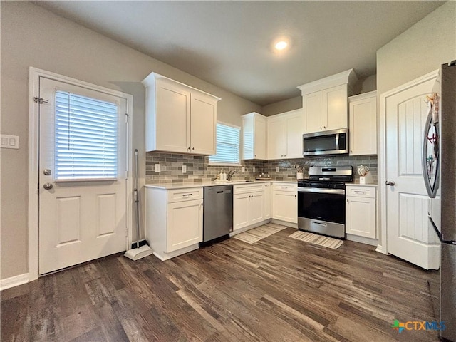 109 Opal Way, Port Lavaca, TX 77979 - kitchen featuring stainless steel appliances, tasteful backsplash, white cabinets, and dark wood-type flooring
