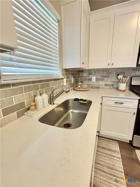 109 Opal Way, Port Lavaca, TX 77979 - kitchen featuring white cabinets, a sink, decorative backsplash, and stainless steel range with electric cooktop