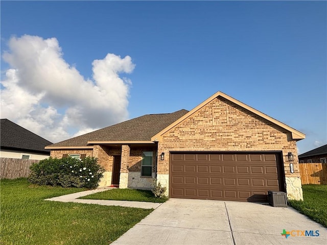 109 Opal Way, Port Lavaca, TX 77979 - ranch-style house with brick siding, an attached garage, concrete driveway, a shingled roof, and stone siding