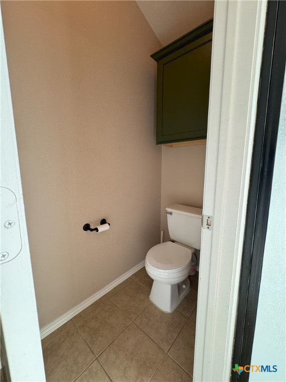 bathroom with toilet and tile patterned flooring