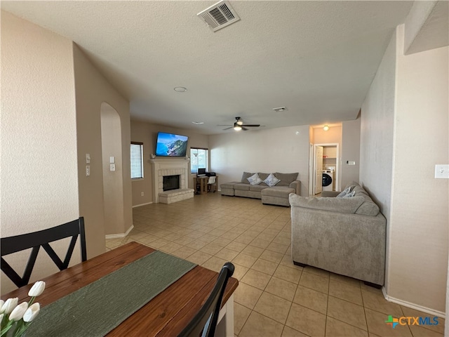 tiled dining room featuring ceiling fan and washer / dryer