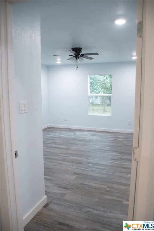 empty room with dark hardwood / wood-style flooring and ceiling fan