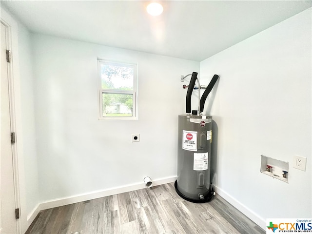 clothes washing area with electric water heater, hookup for an electric dryer, hookup for a washing machine, and hardwood / wood-style flooring