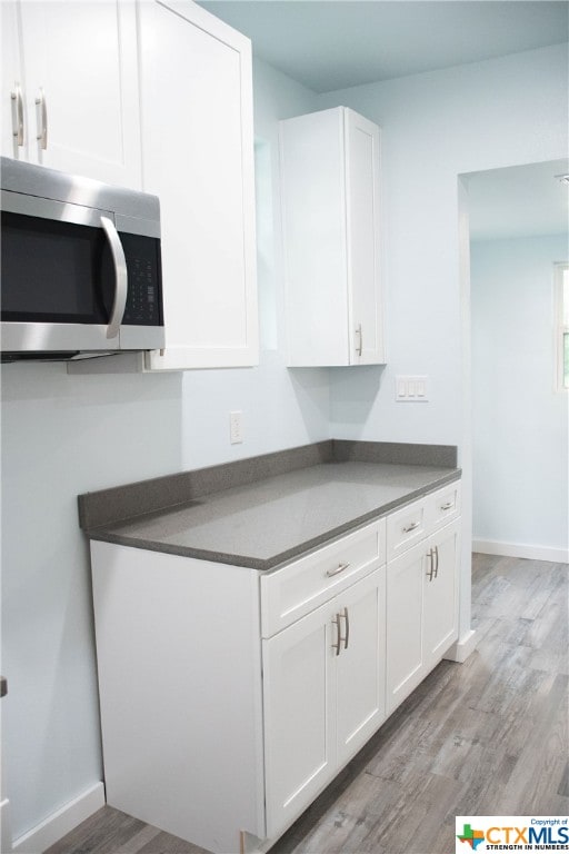 kitchen featuring white cabinetry and light hardwood / wood-style flooring