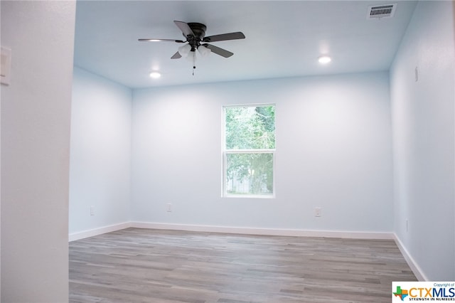 spare room with light wood-type flooring and ceiling fan