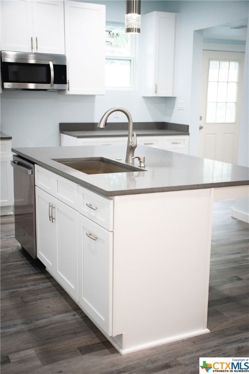 kitchen with appliances with stainless steel finishes, sink, decorative light fixtures, and plenty of natural light