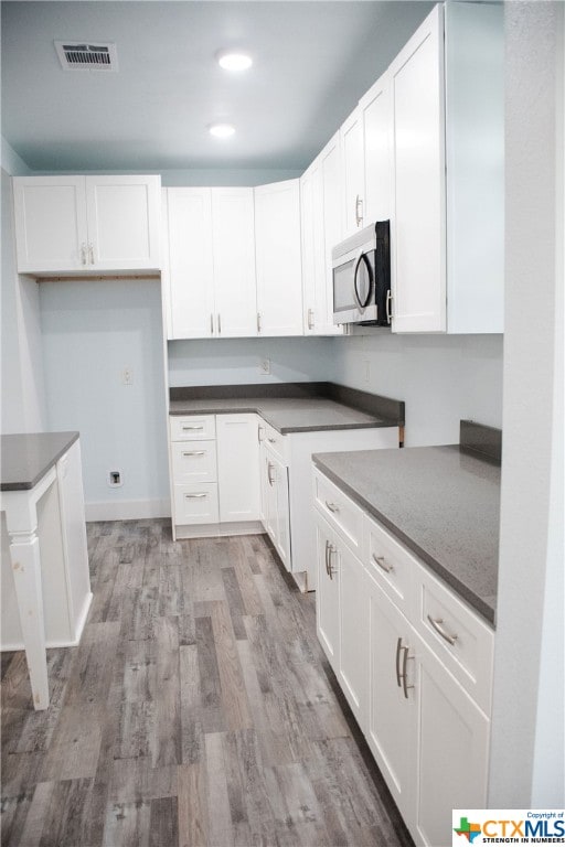 kitchen featuring white cabinets and light wood-type flooring