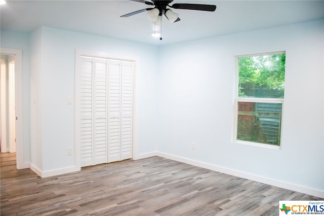 unfurnished bedroom with a closet, light hardwood / wood-style floors, and ceiling fan