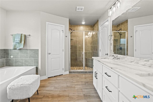 900 Holliday Dr, Killeen, TX 76542 - full bath with a stall shower, a tub, double vanity, wood finished floors, and baseboards