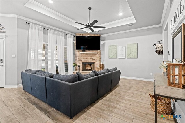 900 Holliday Dr, Killeen, TX 76542 - living area featuring a raised ceiling, a fireplace, ceiling fan, baseboards, and crown molding