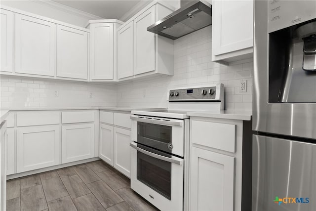 kitchen featuring wall chimney range hood, white cabinetry, double oven range, ornamental molding, and stainless steel fridge with ice dispenser